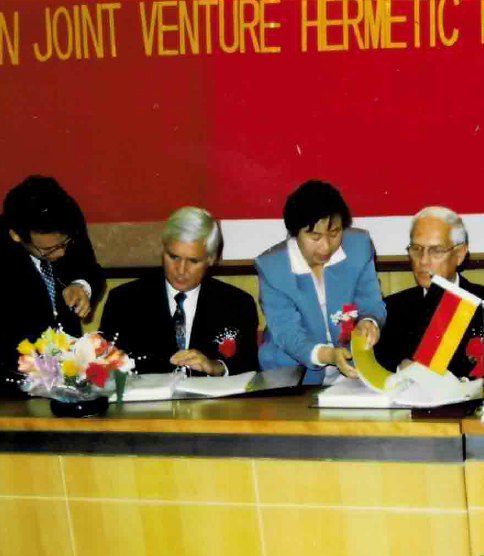 Signing ceremony for the Sino-German joint venture, four people seated at a table