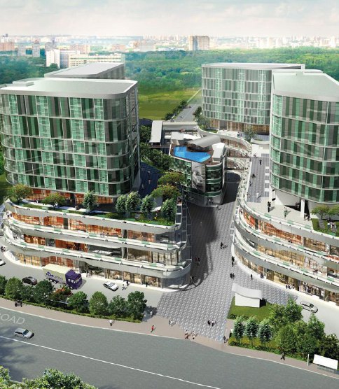 Aerial view of a modern mixed-use development with glass towers and greenery