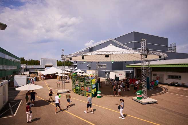 Visitors walking across the HERMETIC site in Gundelfingen past tents and exhibition stands