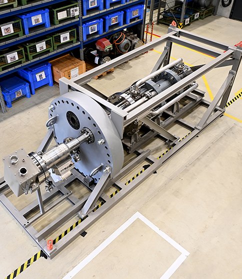 Large pump assembly mounted on a steel frame in a manufacturing hall