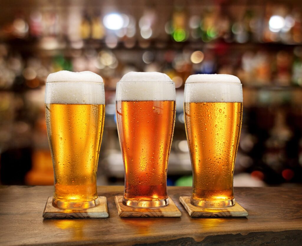 Three glasses of beer on a bar, illustrating growth of the low and no-alcohol beer market