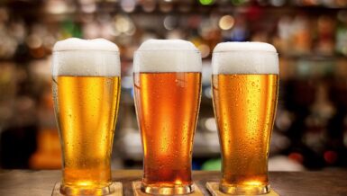 Three glasses of beer on a bar, illustrating growth of the low and no-alcohol beer market