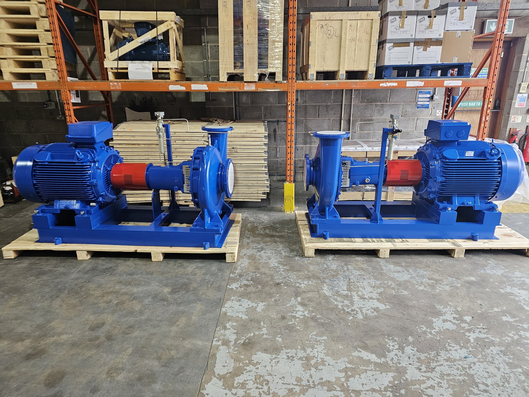Two blue end suction centrifugal pumps with air ejectors on baseplates, ready for shipment to a mining site