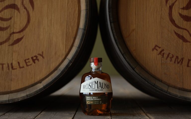 Bottle of Rosemaund 10-year-old single malt English whisky standing between two oak casks