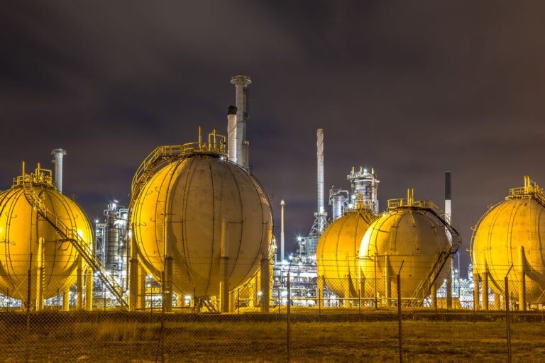 Illuminated spherical gas storage tanks at a processing plant at night