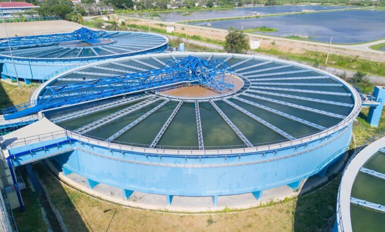 Aerial view of a wastewater treatment plant with circular clarifier tanks