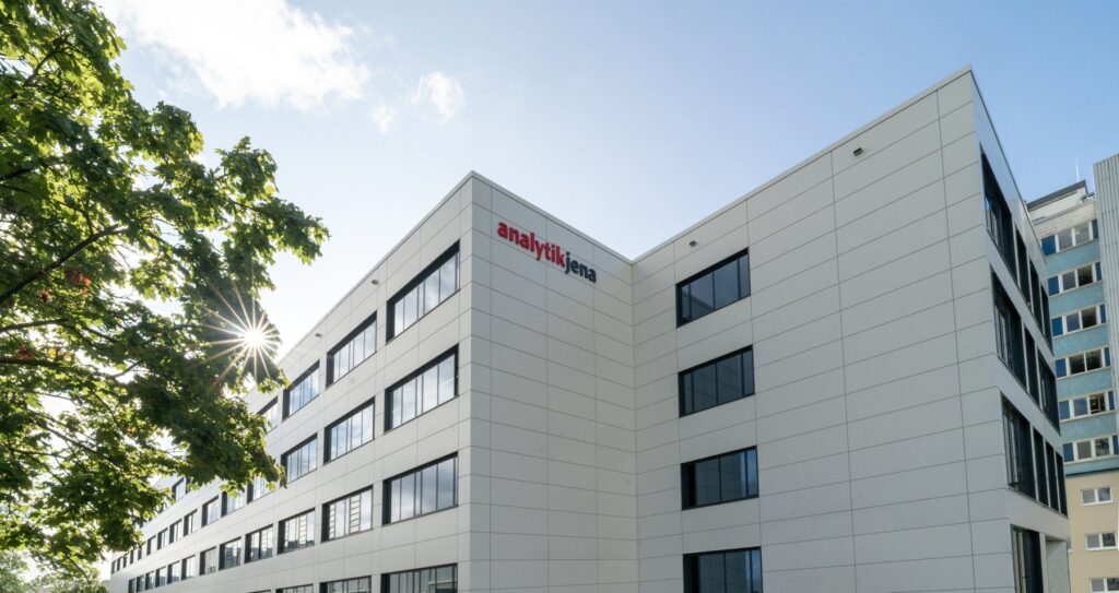 Corner view of the new white Analytik Jena headquarters building in Jena with the company logo on the facade