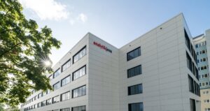 Corner view of the new white Analytik Jena headquarters building in Jena with the company logo on the facade