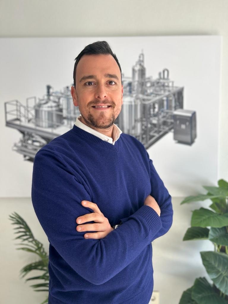 Antonio Guillermo Jara Ponce, European Sales Manager at HRS Heat Exchangers, standing in front of a drawing of a heat exchanger system