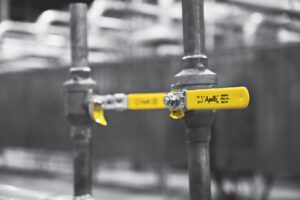Apollo Valves ball valve with yellow handle marked Aalberts IPSA on a piping installation