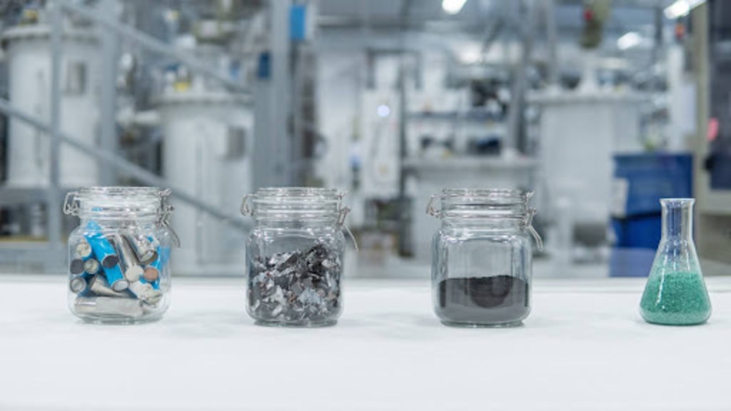 Jars with shredded battery material, black mass and leach solution in a hydrometallurgical recycling laboratory