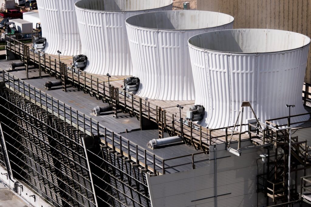 Row of industrial cooling towers with fan stacks on a rooftop, ready for seasonal layup
