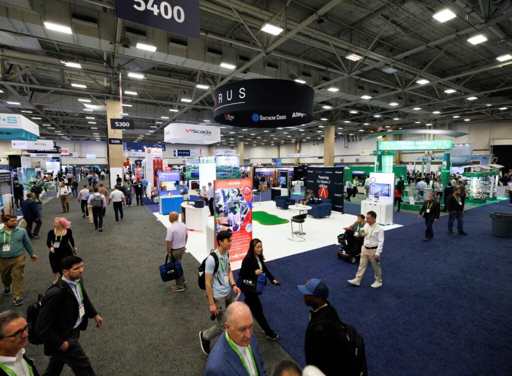 Visitors walking through the DTECH exhibition hall