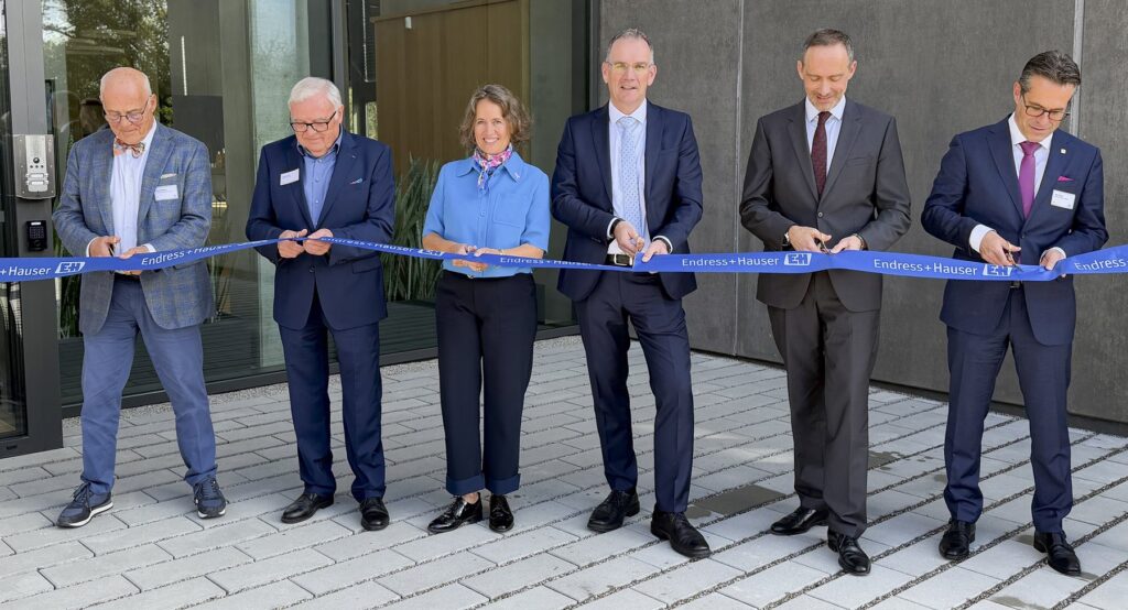 Six people cutting a blue Endress+Hauser ribbon at the inauguration of the new campus building in Cernay, Alsace