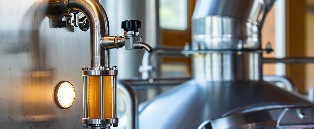 Stainless steel brewing equipment with a sight glass and valves