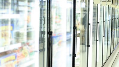 Row of glass-door refrigeration units in a supermarket