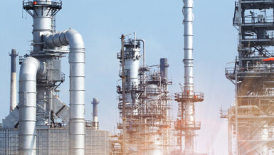 Industrial plant with steel columns and pipework under a blue sky