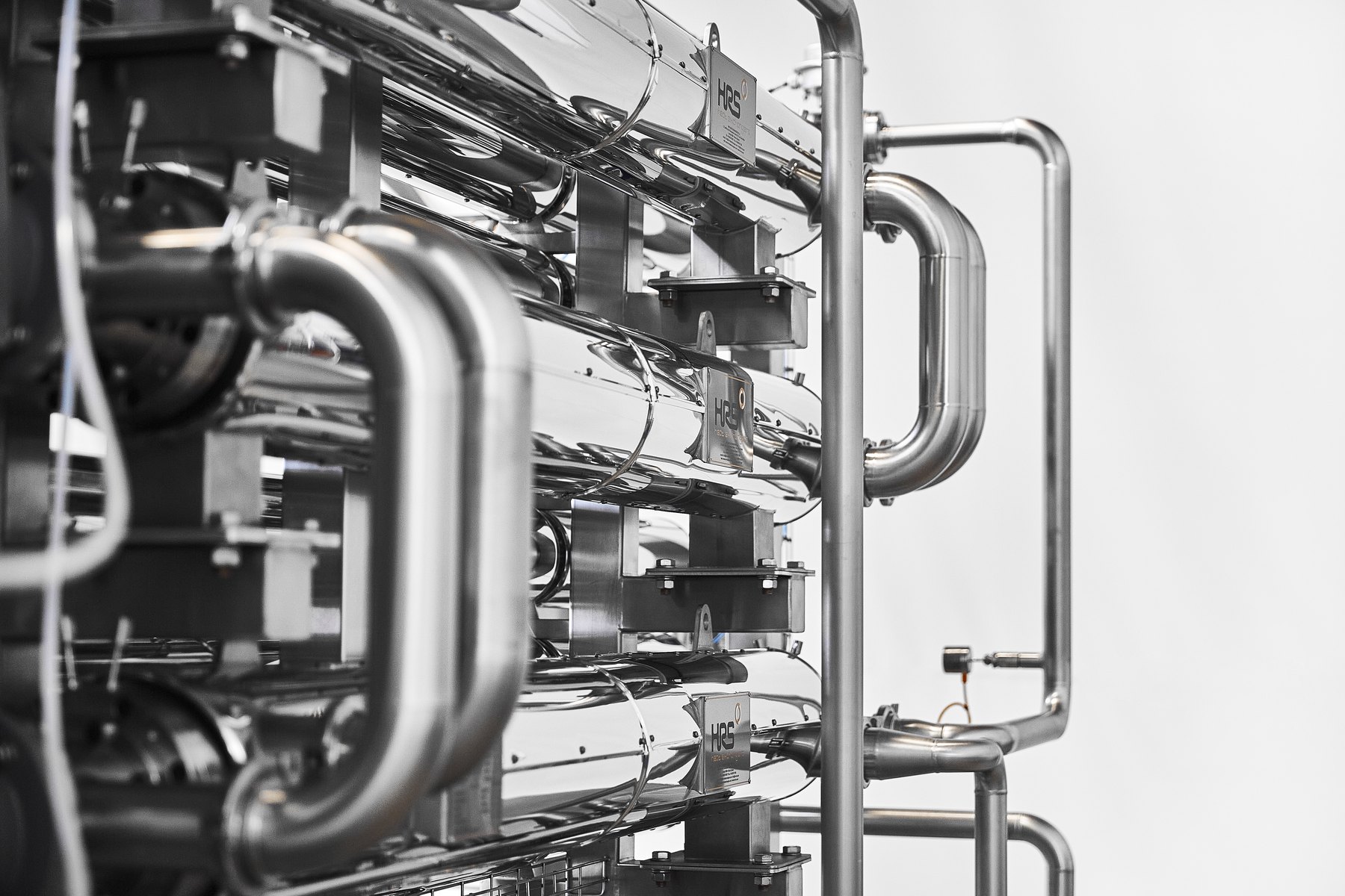 Close-up of polished stainless steel corrugated tube heat exchangers connected by U-bends
