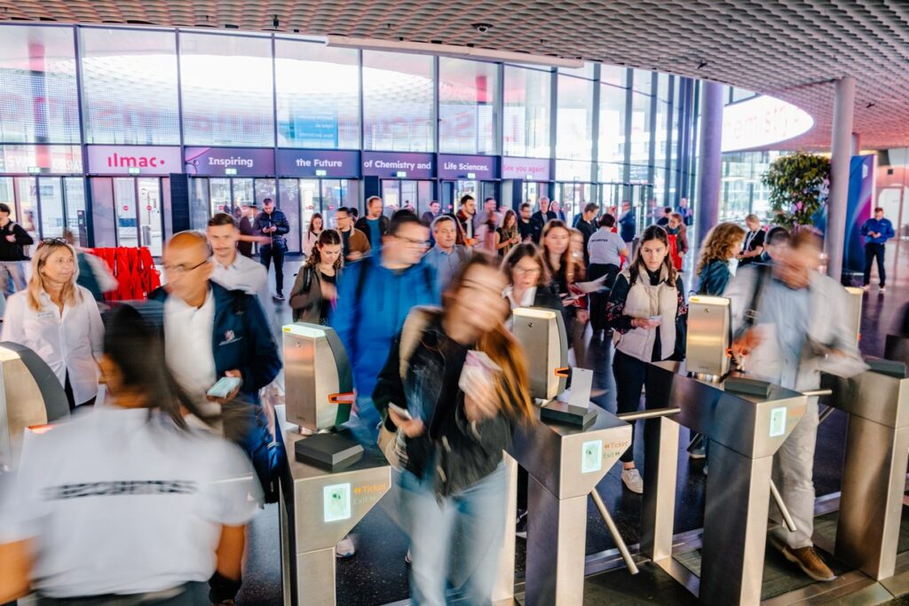 Visitors passing the entrance gates of Ilmac at Messe Basel