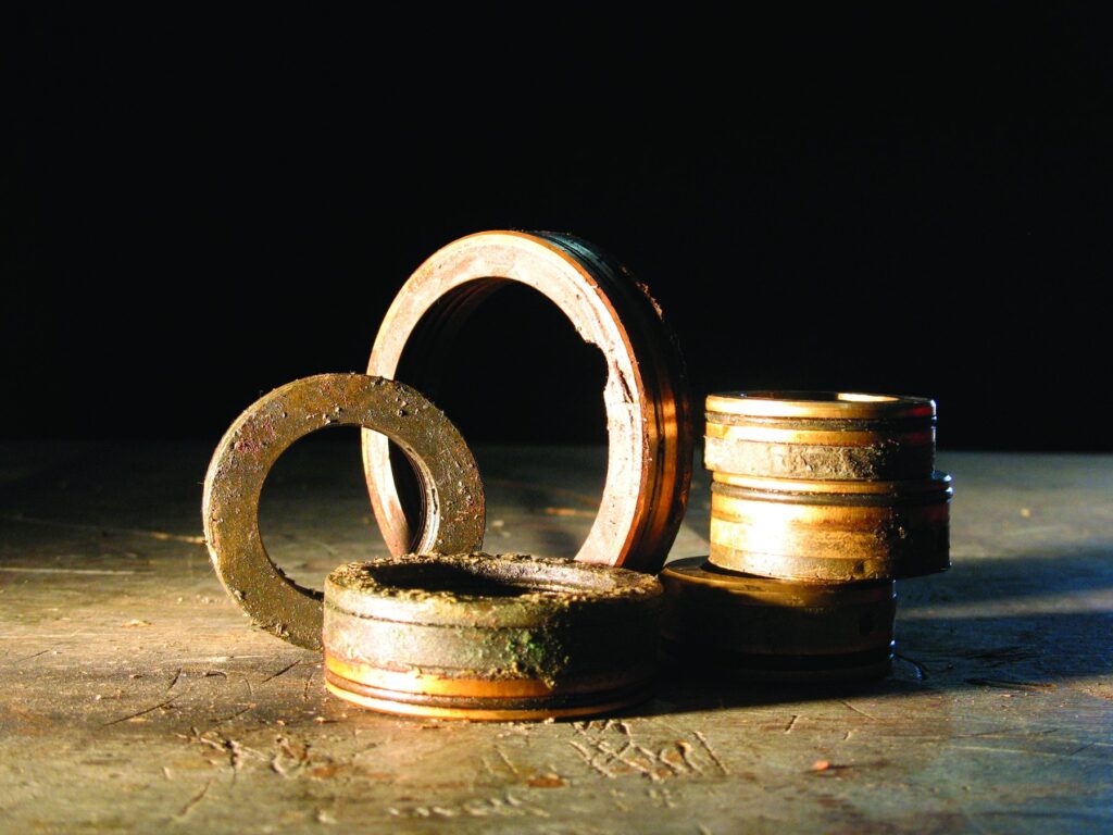 Worn early bearing isolators and seal rings on a workbench