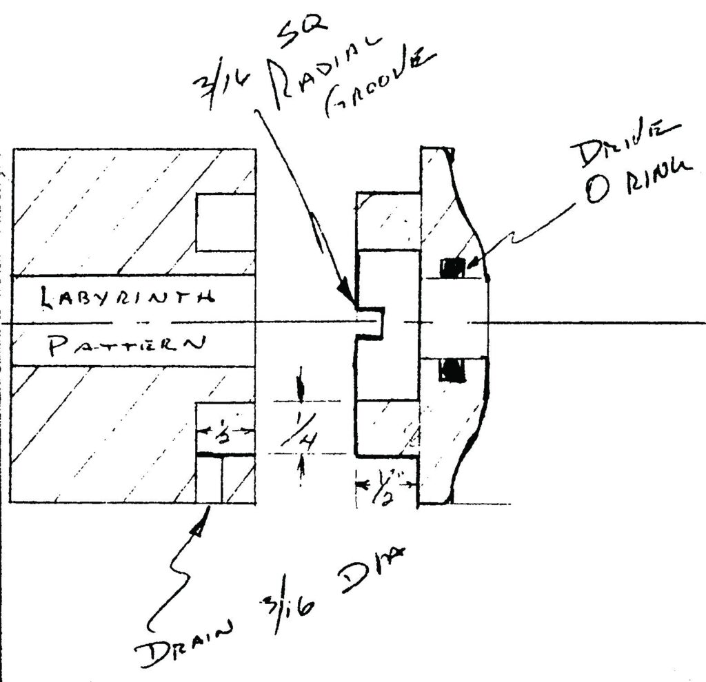 Hand-drawn schematic of the first bearing isolator design with labyrinth pattern, radial groove, drain and drive O-ring
