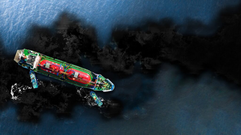 Aerial view of an oil tanker with tugboats surrounded by an oil slick at sea, illustrating pipeline leak detection with electrical resistance tomography