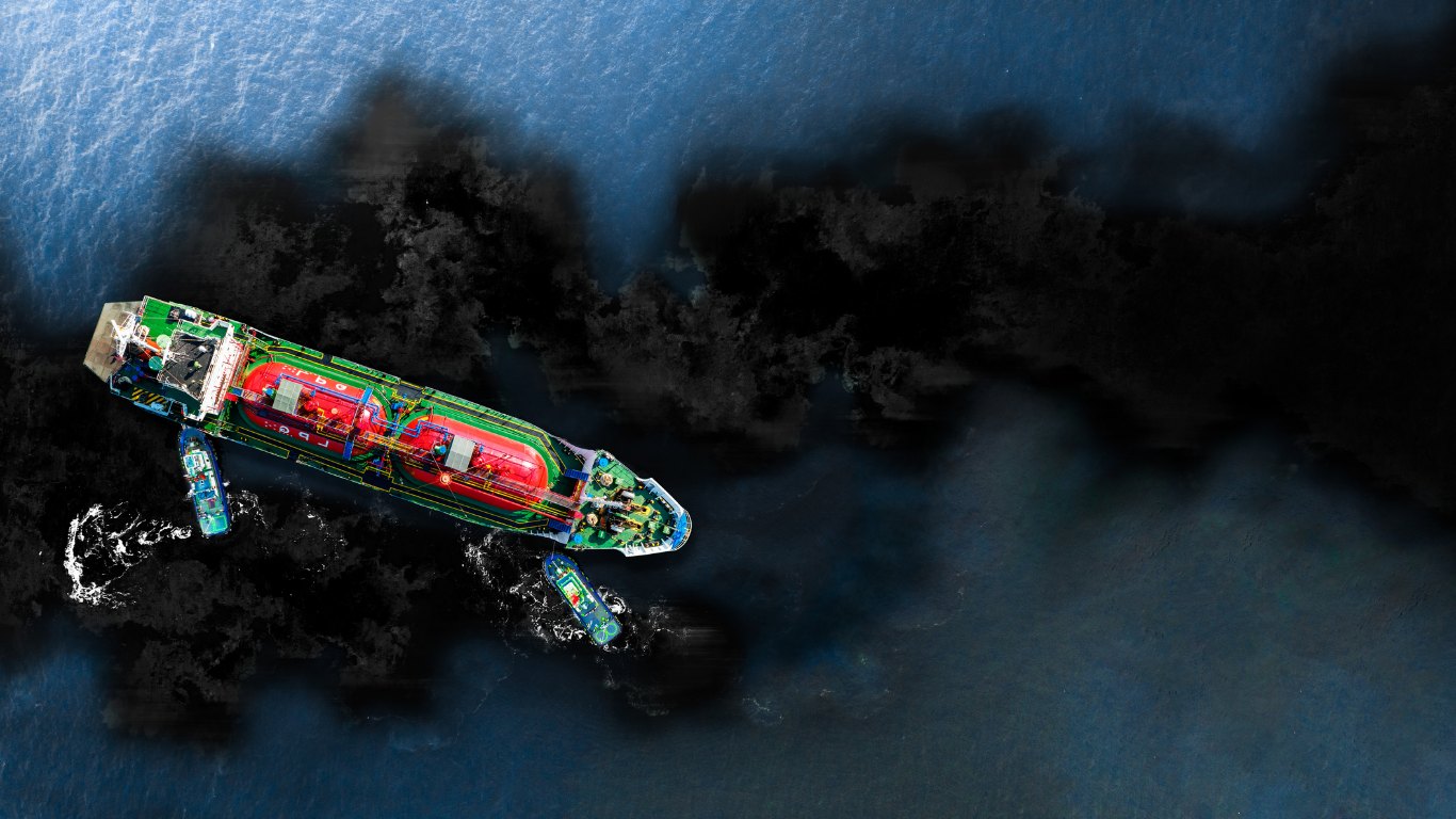 Aerial view of an oil tanker with tugboats surrounded by an oil slick at sea, illustrating pipeline leak detection with electrical resistance tomography