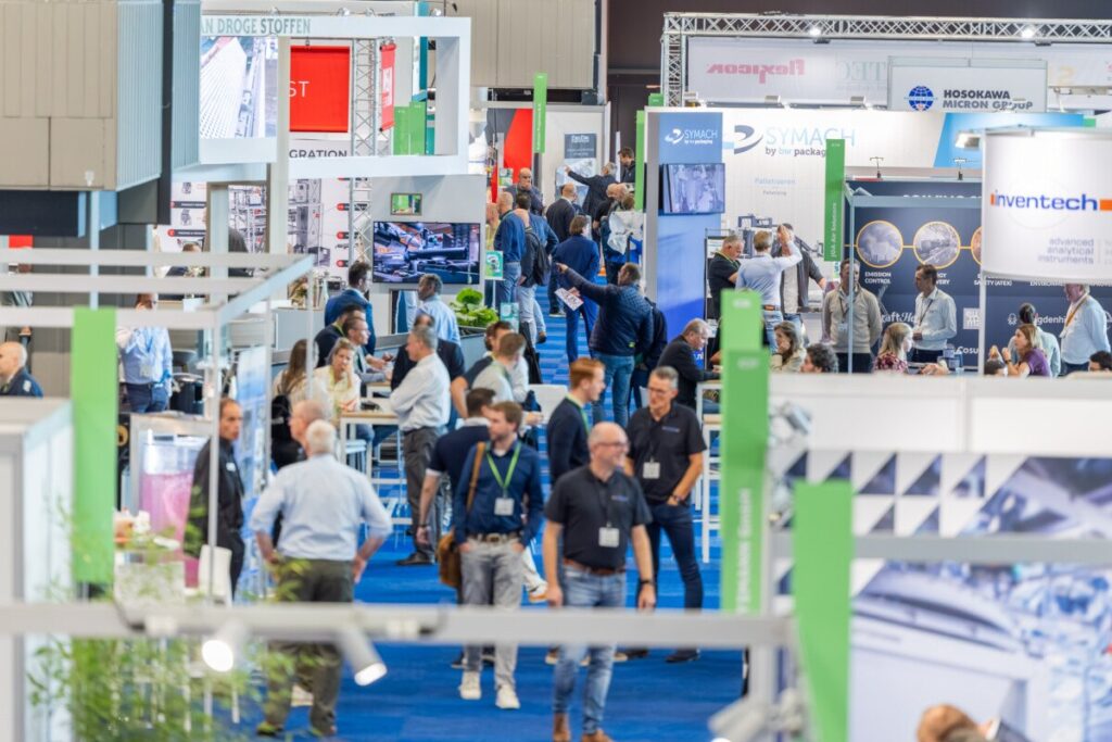 Visitors walking past exhibitor stands on the show floor of Pumps & Valves Rotterdam at Rotterdam Ahoy